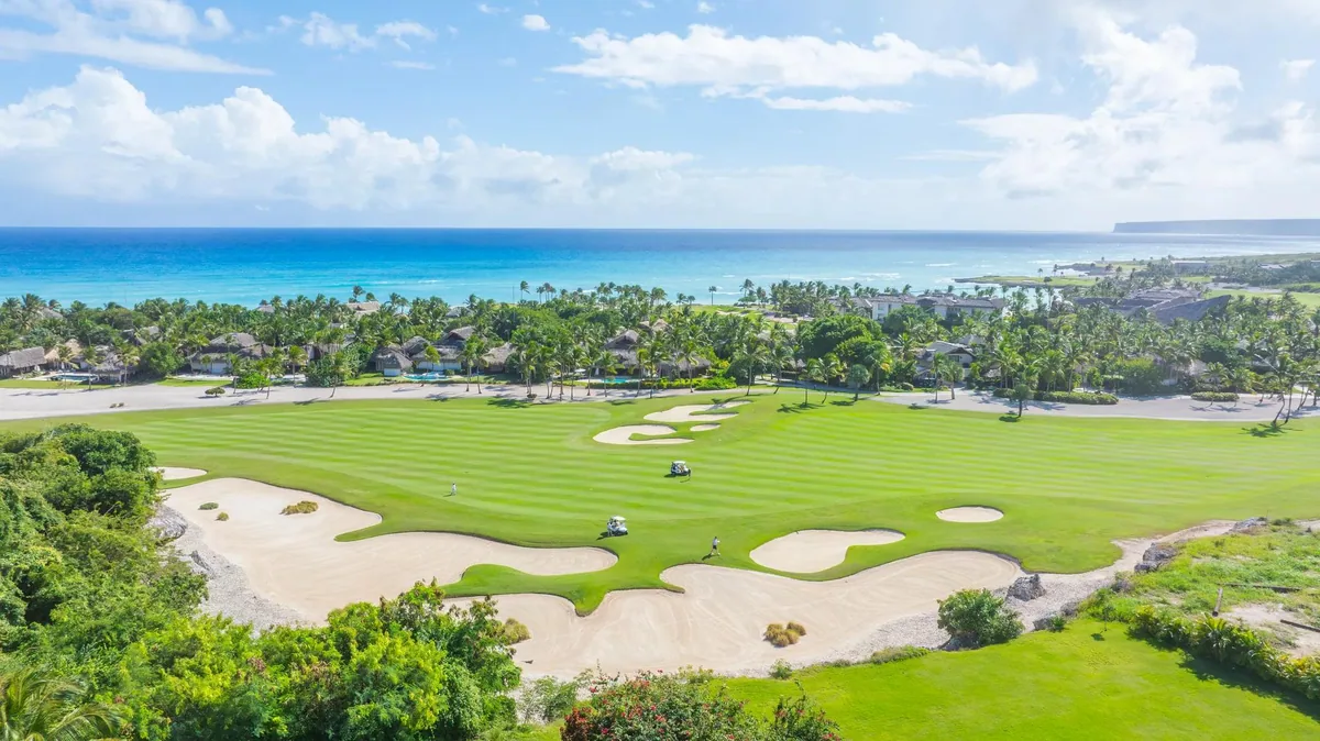 A lawn running down towards the sea, palms at its edge